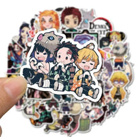 A mixed pack of waterproof Demon Slayer Stickers featuring cute Tanjiro and Nezuko anime art, applied to a laptop and phone case.