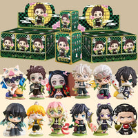 A colorful Demon Slayer Blind Box containing a random cute PVC anime figure of Tanjiro or Nezuko, used as a desktop ornament.
