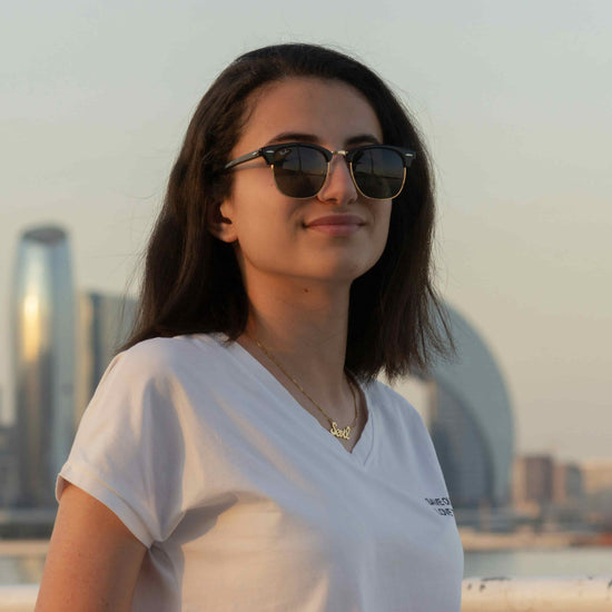 Woman wearing sunglasses with a city skyline in the background