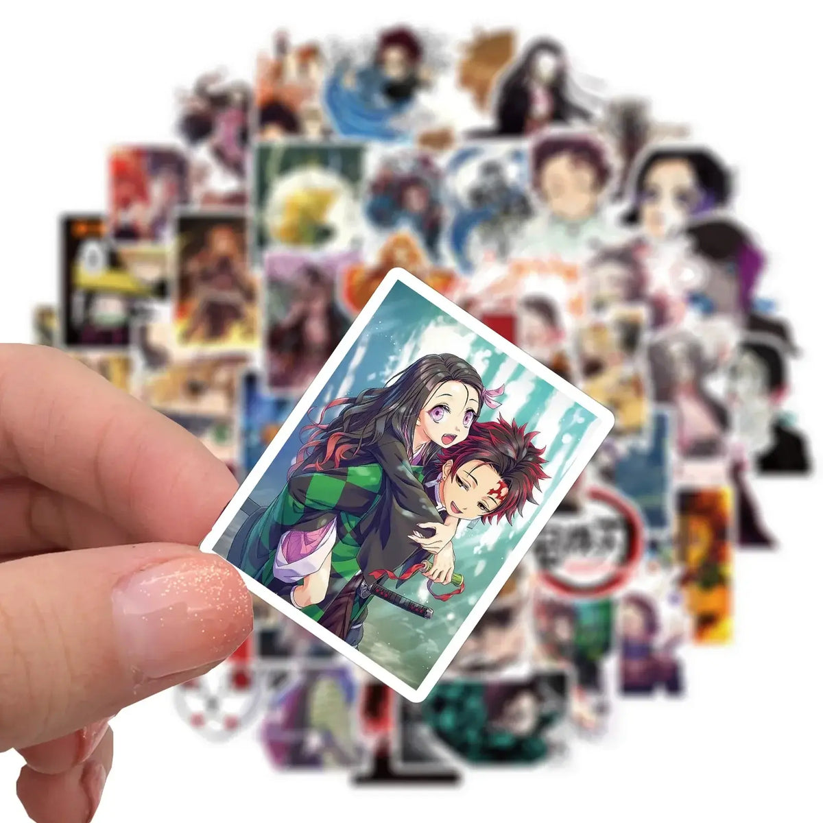A mixed pack of waterproof Demon Slayer Stickers featuring cute Tanjiro and Nezuko anime art, applied to a laptop and phone case.