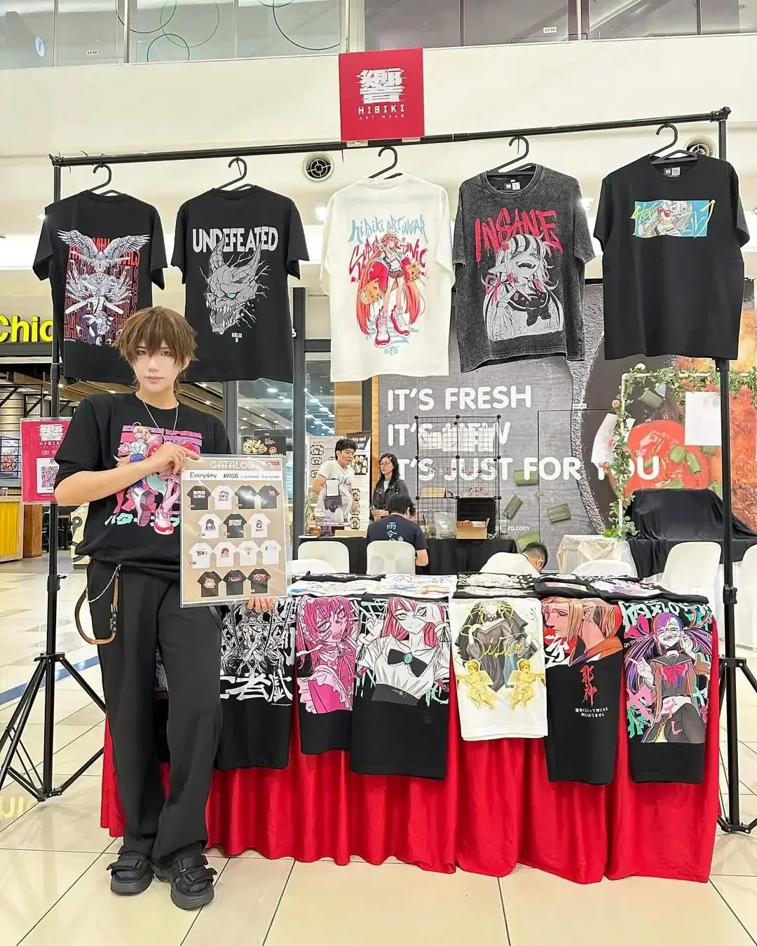 Bleach T-Shirt Vintage Washed Anime Streetwear display at a market featuring various graphic tees and a young model.