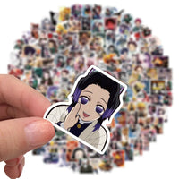 A mixed pack of waterproof Demon Slayer Stickers featuring cute Tanjiro and Nezuko anime art, applied to a laptop and phone case.