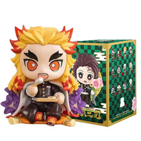 A colorful Demon Slayer Blind Box containing a random cute PVC anime figure of Tanjiro or Nezuko, used as a desktop ornament.
